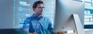 Mann mit Brille im Büro für einem Monitor
