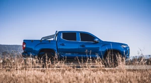 blauer Maxus ET90 Pickup von der Seite auf einem Feldweg