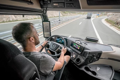 Mann am Steuer eines Mercedes-Benz Actros LKW auf der Autobahn
