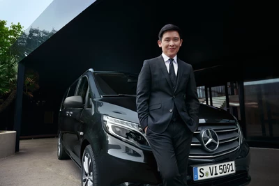 Mann im ANzug steht vor einem Mercedes-Benz Vito schwarz