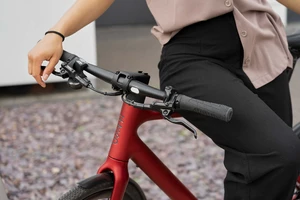 URWAHN eBike Stadtfuchs rot mit Person die sich an das Fahrrad lehnt