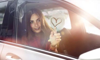 Auto Mercedes von außen mit junger Frau und Herz an der Scheibe