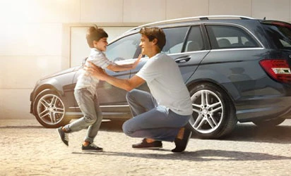 Kind läuft Vater in die Arme vor einem Mercedes Benz